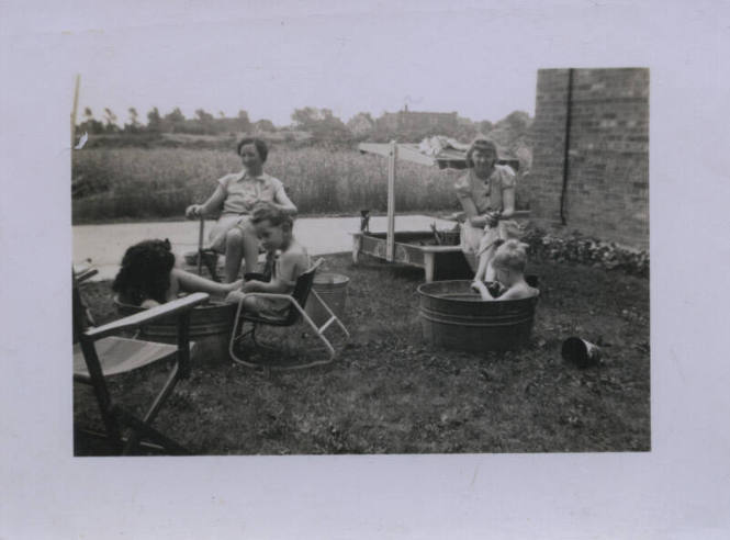 Untitled [Two women and three children sit in lawn]