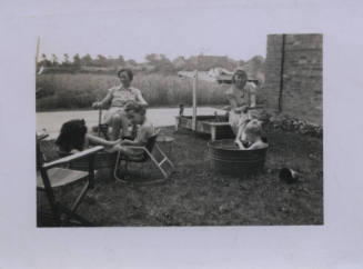 Untitled [Two women and three children sit in lawn]