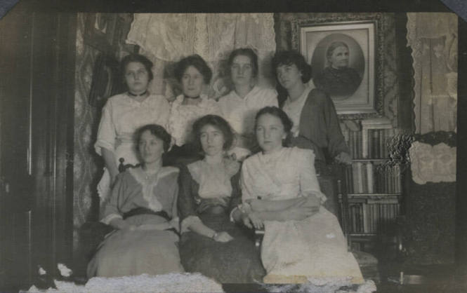 Untitled [Seven women sit and stand together]