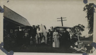Untitled [Crowd stands in front of two cars and tent]