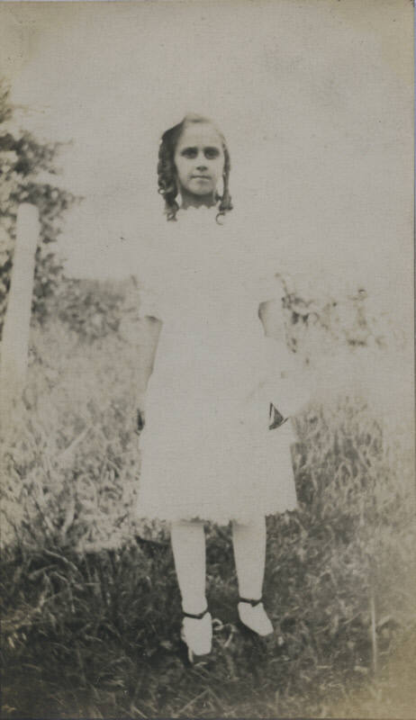 Untitled [Woman stands on field of high grass]