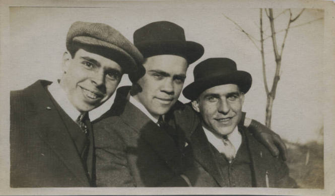 Untitled [Three men wear hats, tree in the background]