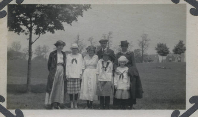 Untitled [Two women, a man, and three children stand on field]