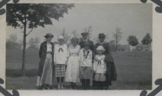 Untitled [Two women, a man, and three children stand on field]
