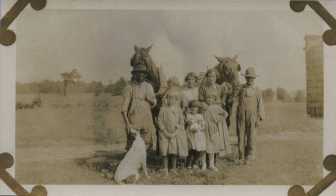 Untitled [Two women, a man, and five children stand with two horses, a cat, and a dog]