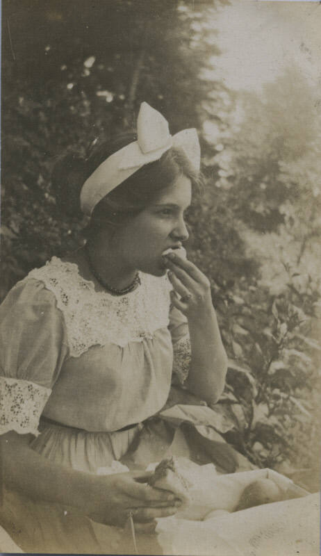 Untitled [Girl eats bread, wears bow in head]