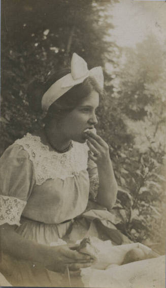 Untitled [Girl eats bread, wears bow in head]