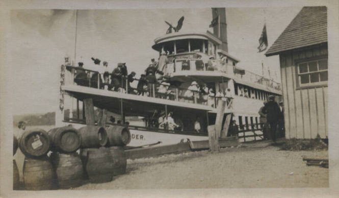Untitled [People on ship next to land]