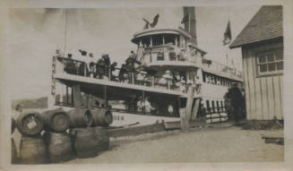 Untitled [People on ship next to land]