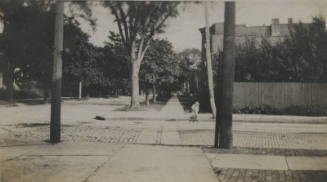 Untitled [Boy pulls cart on street]