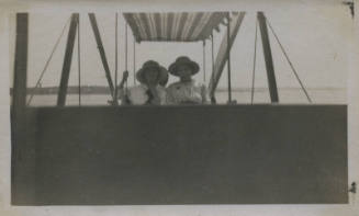 Untitled [Two women sit on ferris wheel cart]