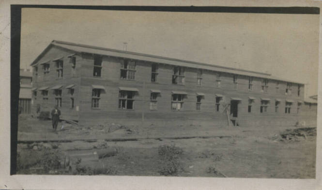 Untitled [Man stands in front of building]
