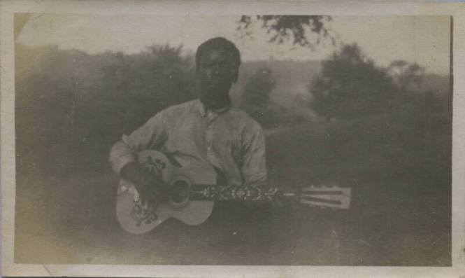 Untitled [Man holds guitar]