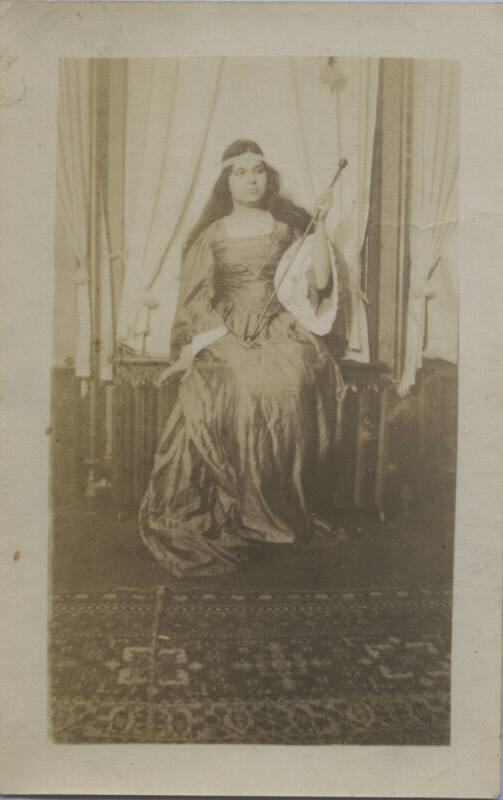 Untitled [Woman sits on windowsill, holds stick]