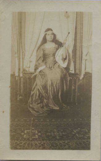 Untitled [Woman sits on windowsill, holds stick]