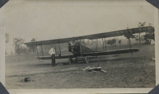 Untitled [Man stands in front of aeroplane]