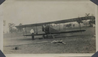 Untitled [Man stands in front of aeroplane]