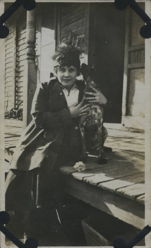 Untitled [Woman sits on porch, holds dog]