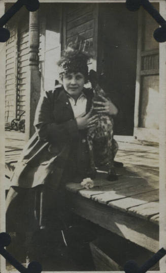 Untitled [Woman sits on porch, holds dog]