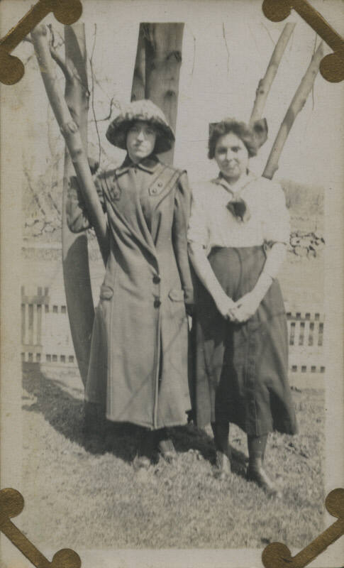 Untitled [Two women stand in front of tree]