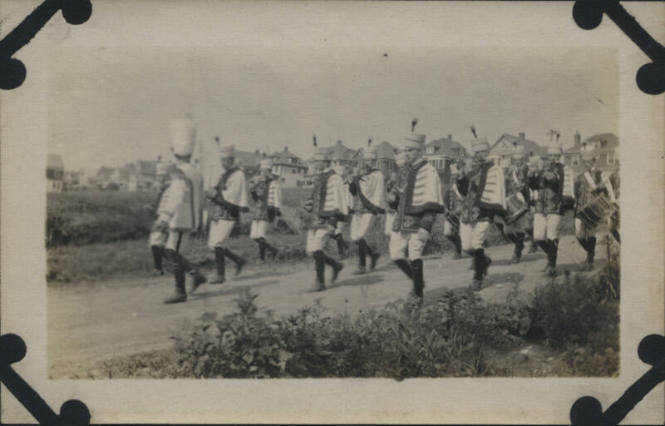 Untitled [Marching band walks down road]