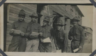 Untitled [Five men stand together, wear uniforms, hold paper in hand]