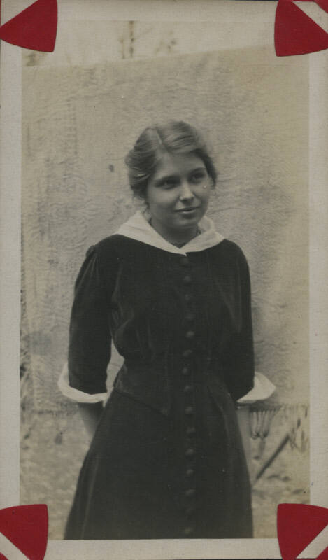 Untitled [Woman stands, hands behind back]