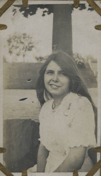 Untitled [Woman sits, body of water in background (#22 duplicate)]
