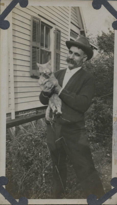 Untitled [Man holds cat]