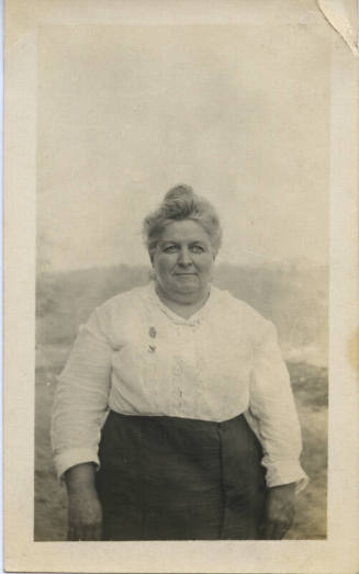 Untitled [Woman stands on field, looks away]