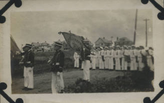 Untitled [Men in uniform stand in procession formation]