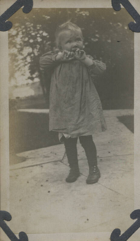 Untitled [Child holds hands up to mouth]