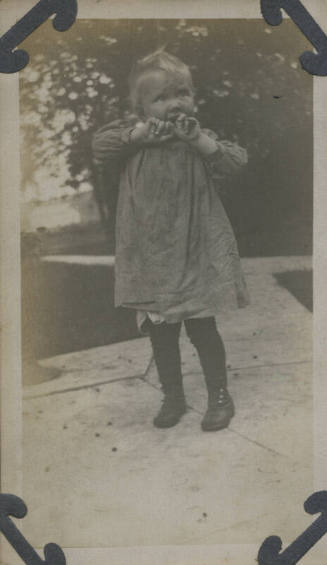 Untitled [Child holds hands up to mouth]
