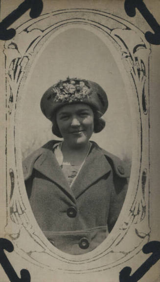 Untitled [Woman wears coat and hat with flowers]
