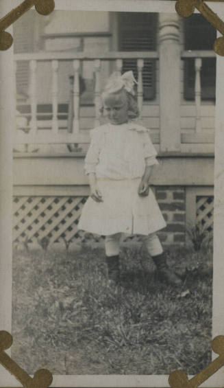 Untitled [Child stands in lawn]