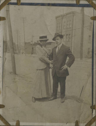 Untitled [Woman and man stand on street]