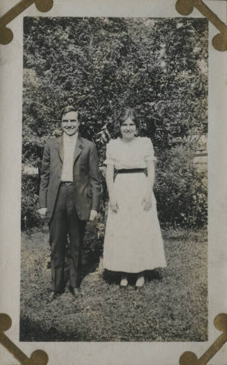Untitled [Woman and man stand on lawn]