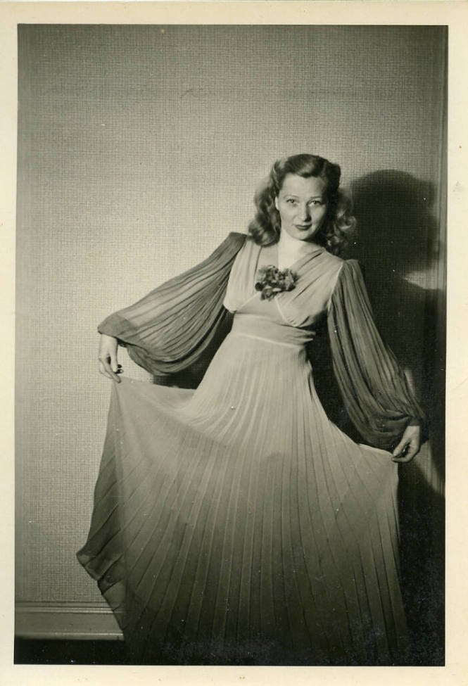 Untitled [Woman holds up dress skirt in gradient and leans to one side, her shadow in the background]