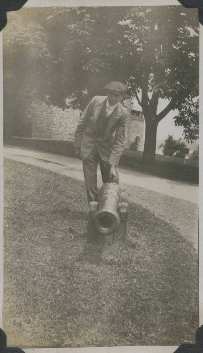 Untitled [Man leans down to touch cannon]