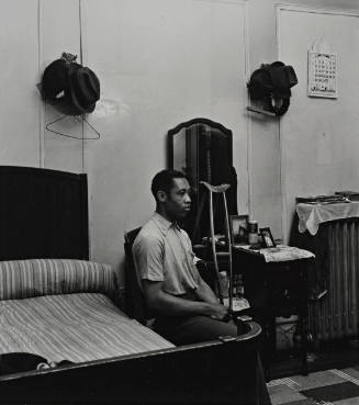 Untitled [3/4 view of sitting man in bedroom with crutch], from the series Harlem Document
