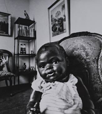 Black Doll Sitting in Room