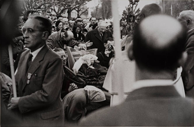 Men with cameras in crowd of pilgrims, Lourdes