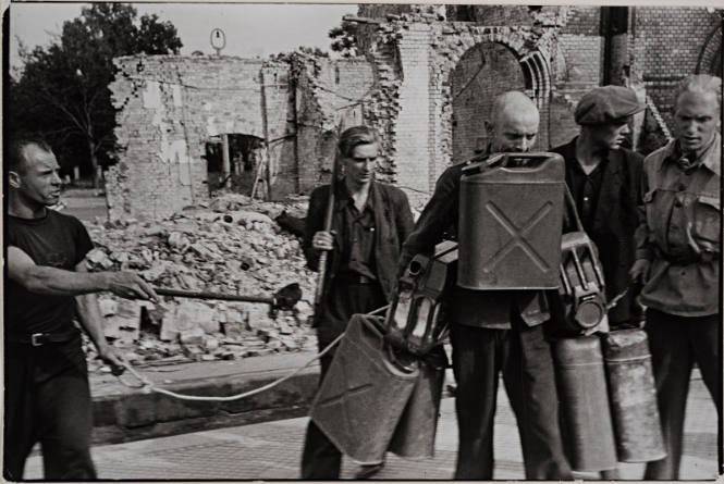 Workers carrying gas cans