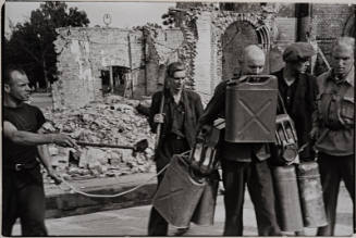 Workers carrying gas cans