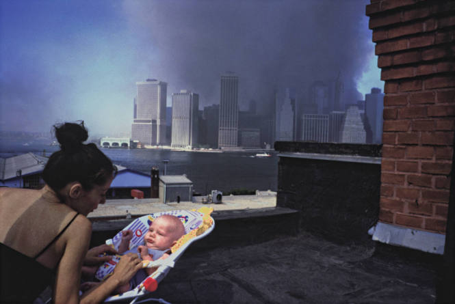 [Smoke behind woman and child on rooftop]