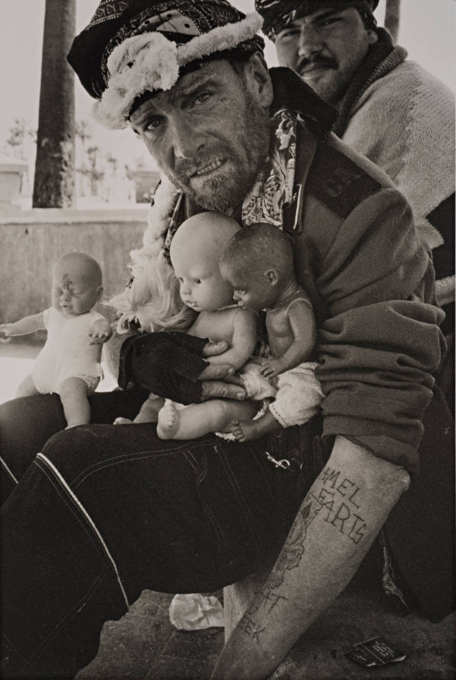 Man holding three dolls, Venice Beach, California