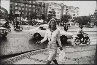 Untitled, from Women are Beautiful [Young Woman Walking with Very Tight Blouse, Traffic Behind]