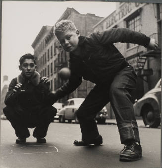 NYC boy playing ball with friend in street