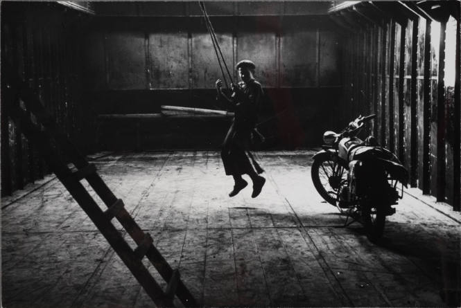 Bram on a swing in the hull of the ship where he spends his free time, Amsterdam, Holland