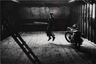 Bram on a swing in the hull of the ship where he spends his free time, Amsterdam, Holland
